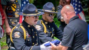 Sergeant Mark Tappan receives K9 Mattis flag from the police honor guard